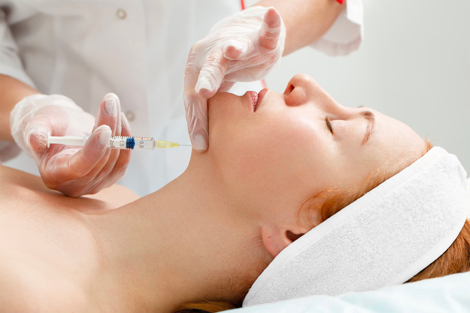 Mujer recibiendo un tratamiento cosmético en el rostro.