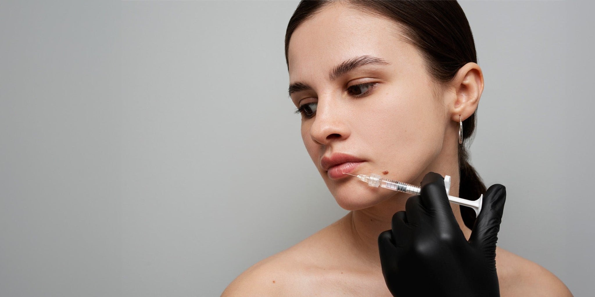 Mujer recibiendo un tratamiento cosmético en su labio. 