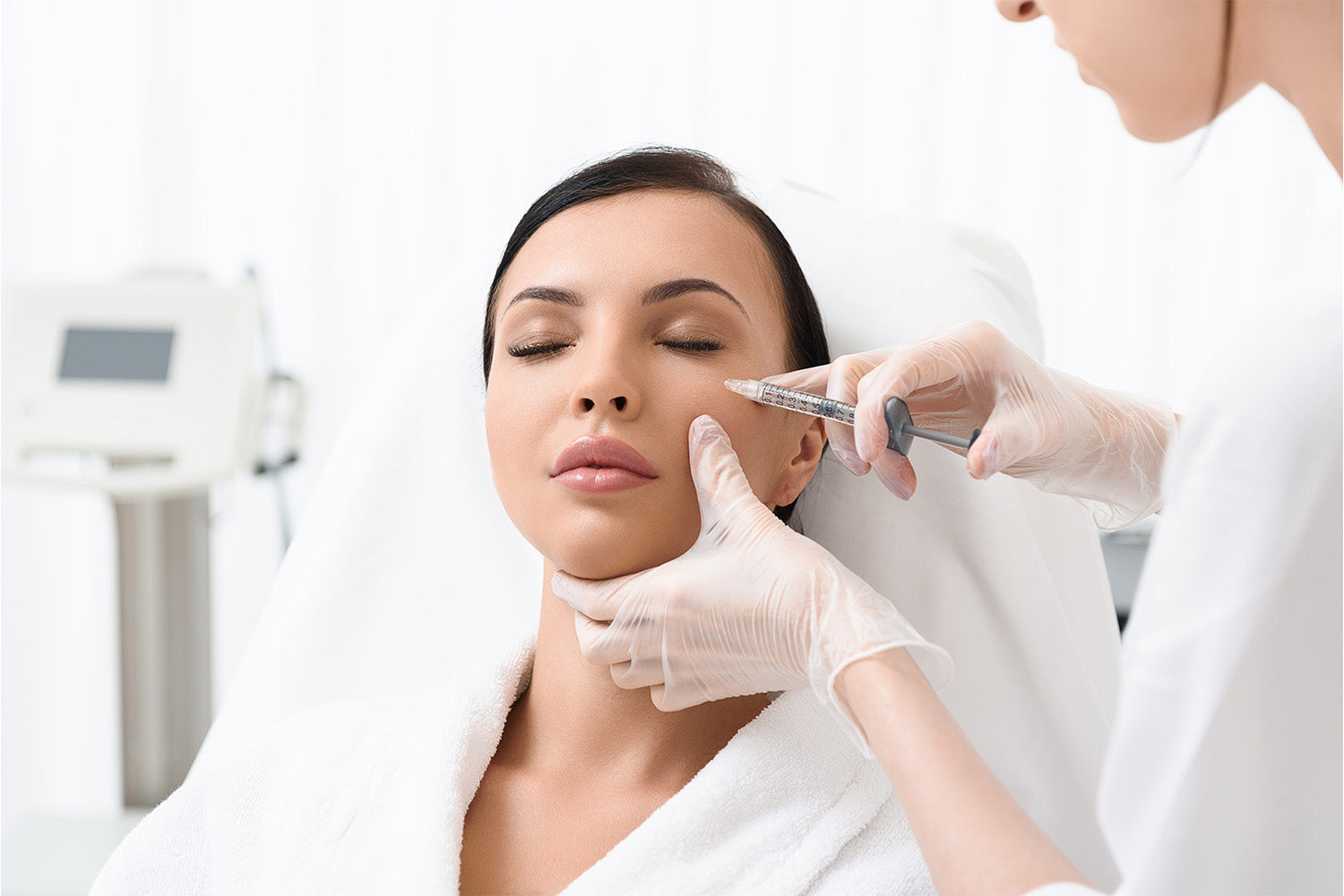 Mujer recibiendo un inyectable en el rostro.