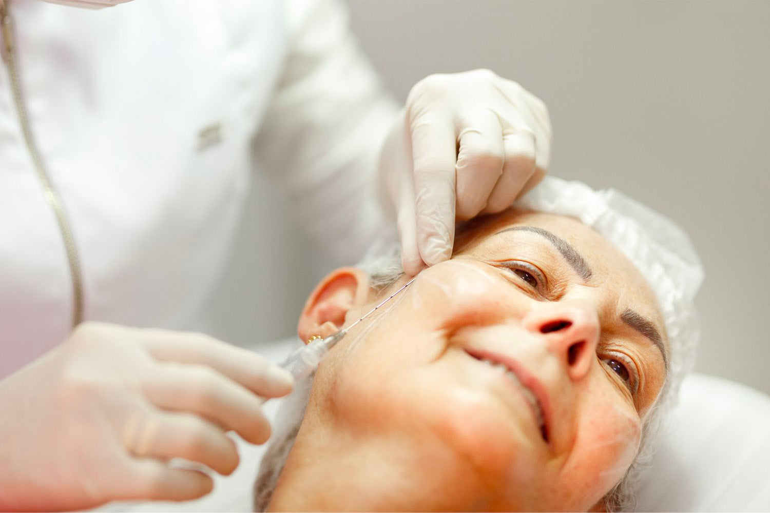 Mujer recibiendo un tratamiento cosmético en el rostro.