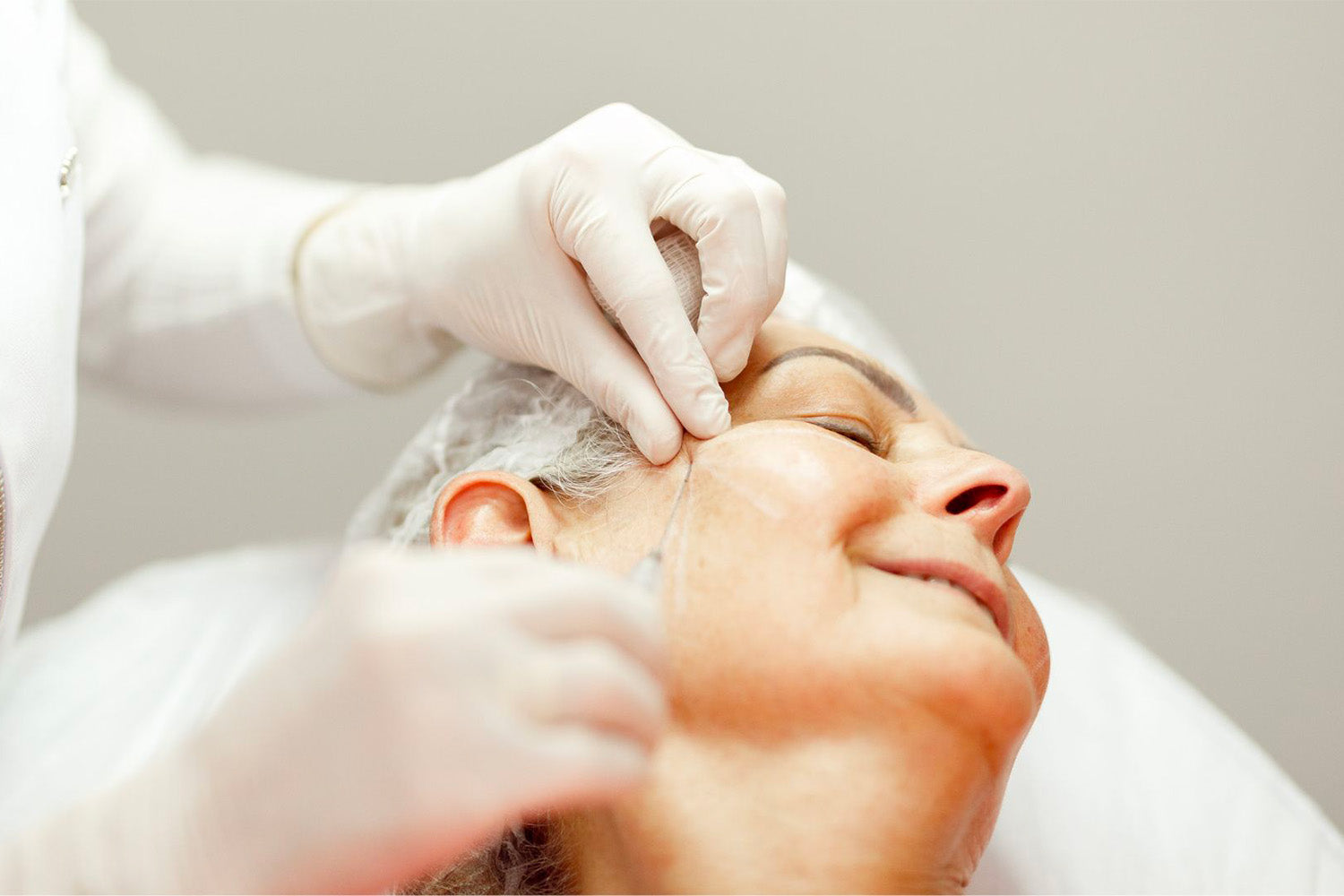 Mujer recibiendo un tratamiento cosmético en el rostro.