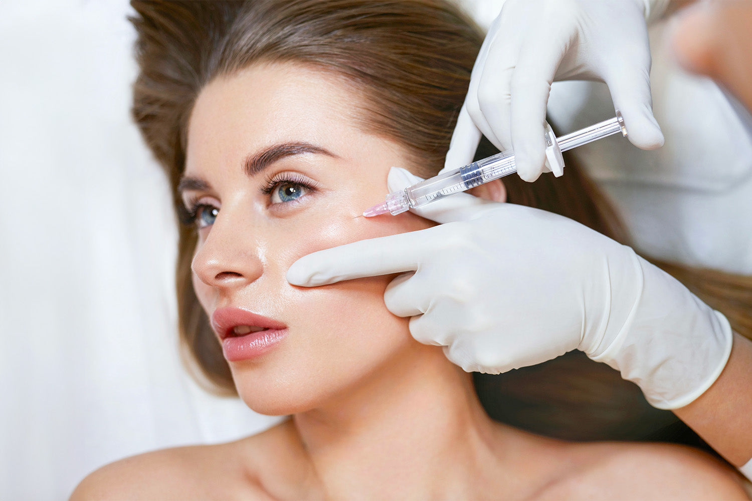 Mujer recibiendo un tratamiento cosmético en el rostro.