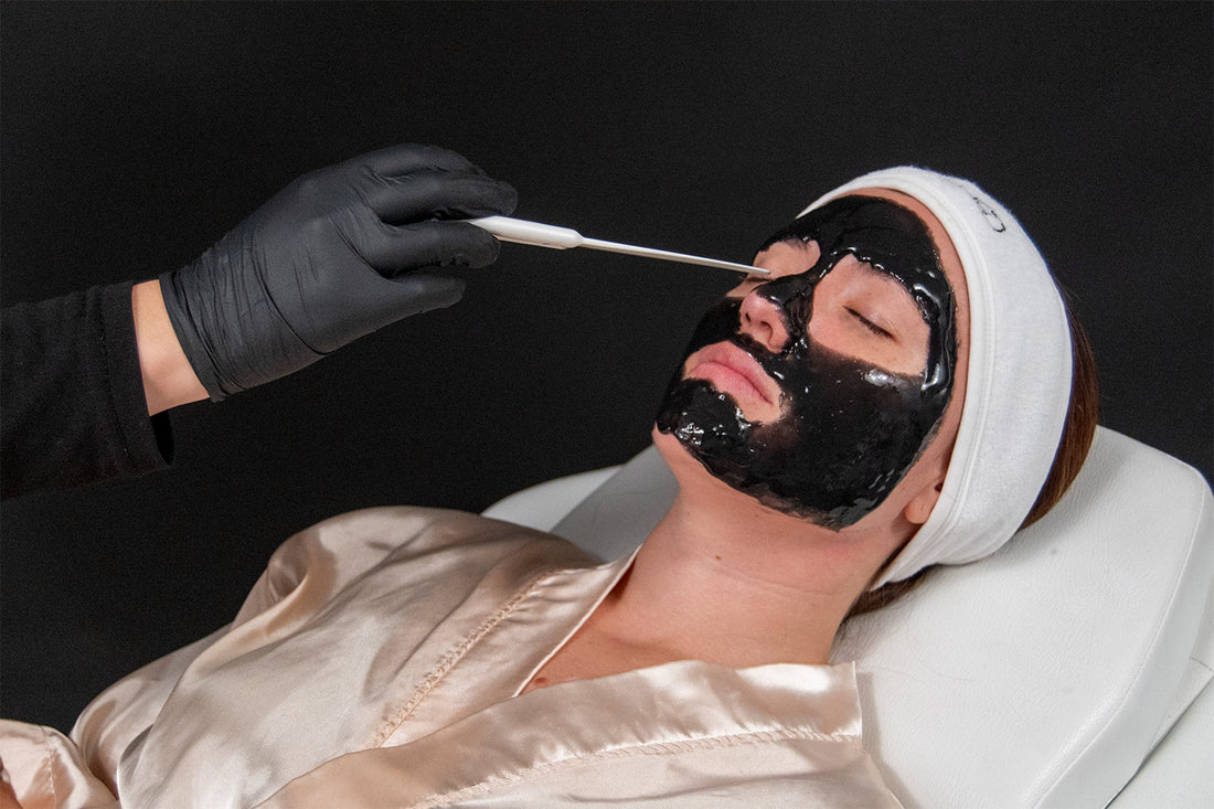 Mujer recibiendo facial de color negro.