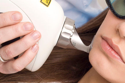 Mujer recibiendo tratamiento cosmético en el rostro.