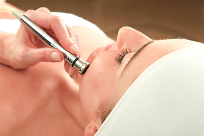 Mujer recibiendo tratamiento cosmético en su rostro.