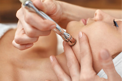 Mujer recibiendo tratamiento cosmético en su rostro.